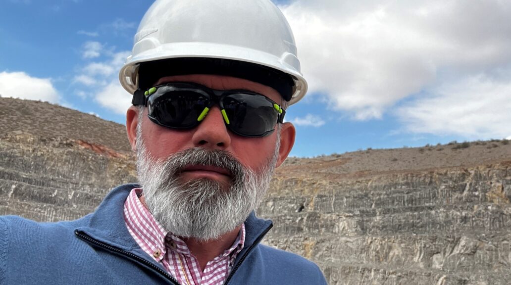 Daniel in a mining site wearing a helmet and shades.
