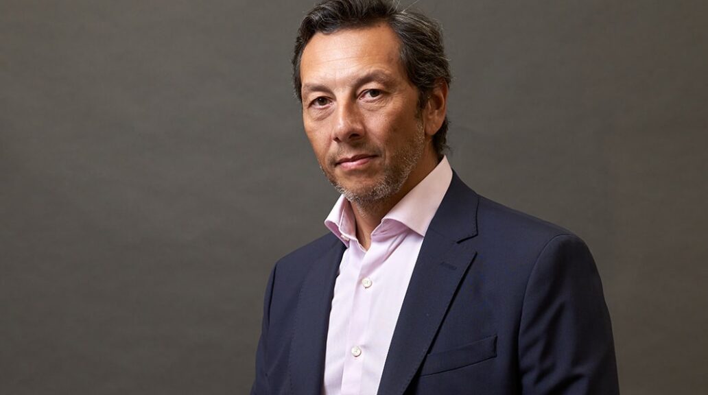 A portrait of Felipe in a jacket and shirt.